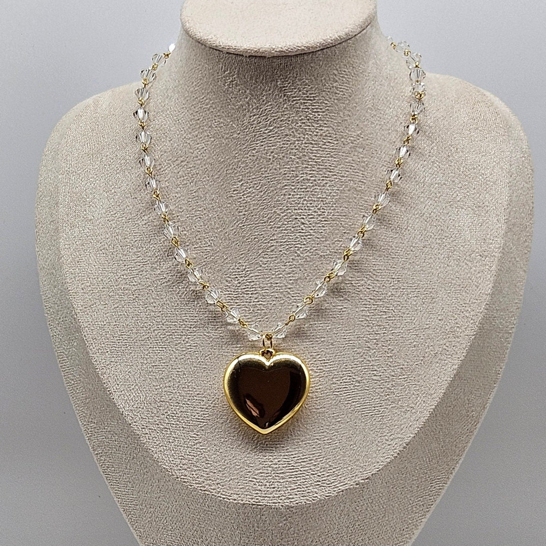 Necklace with a heart-shaped pendant on a mannequin bust against a gray background