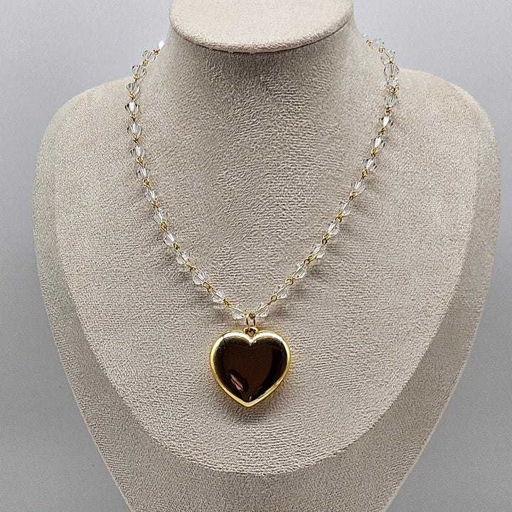 Necklace with a heart-shaped pendant on a mannequin bust against a gray background