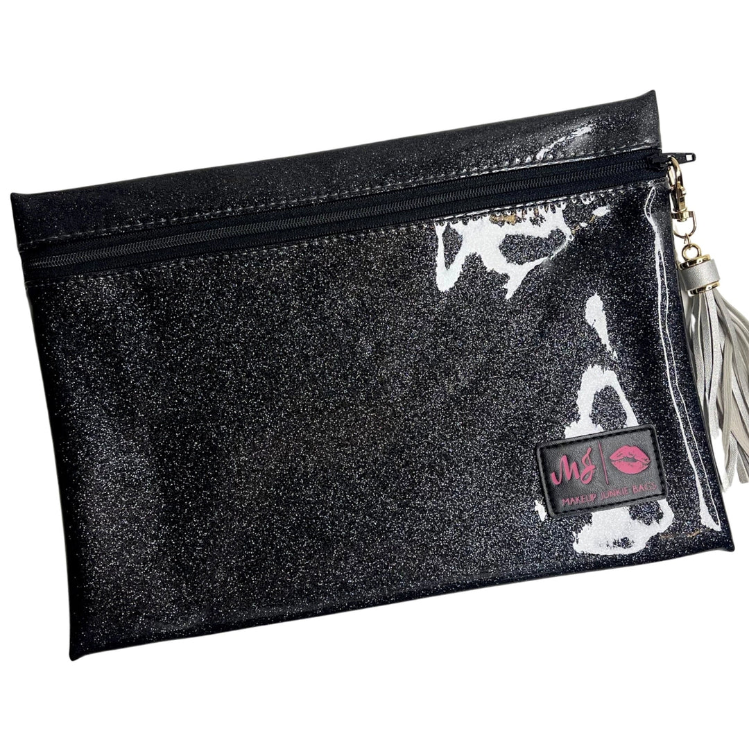 Makeup Junkie Bags grey charcoal stardust glitter clear vinyl zip makeup bag with silver tassel zipper pull and branded patch, front view on white background