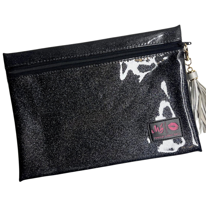 Makeup Junkie Bags grey charcoal stardust glitter clear vinyl zip makeup bag with silver tassel zipper pull and branded patch, front view on white background