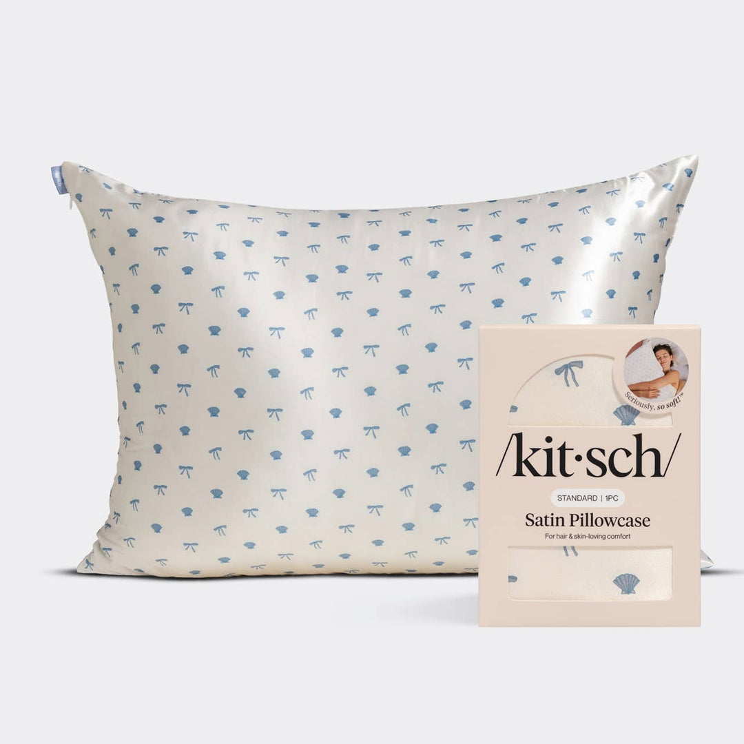 Kitsch standard satin pillowcase in cream with a blue seashell and bow print pattern, shown with its retail packaging box.