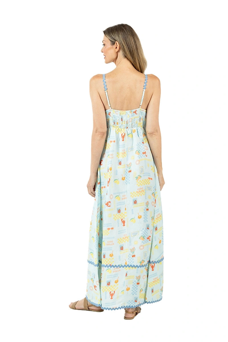 Back view of woman in a light blue lobster and summer print maxi dress showing the smocked back bodice, blue ric-rac trim, and spaghetti straps.