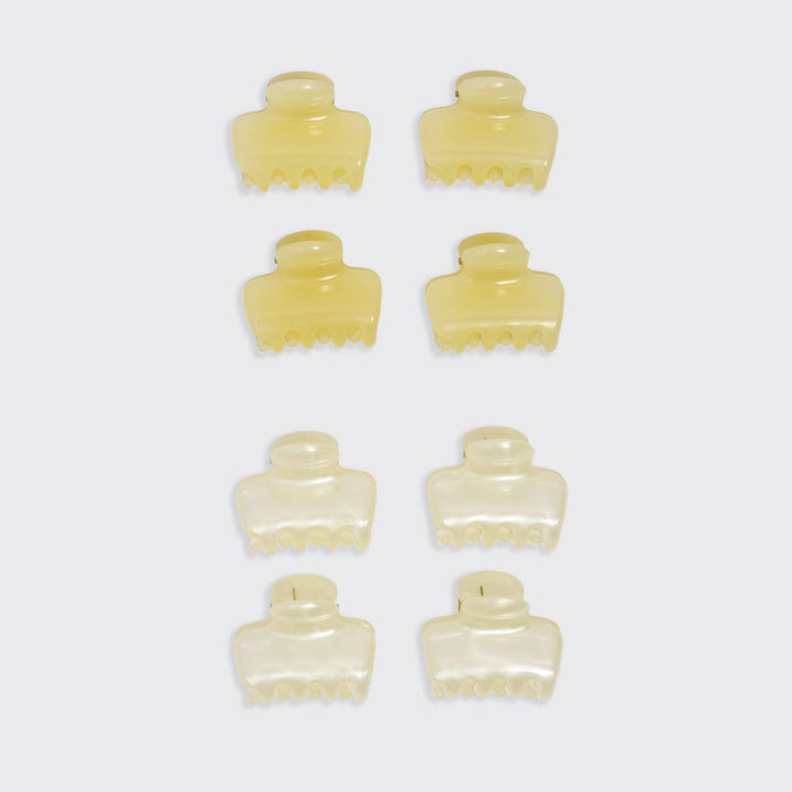 Flat lay of eight mini cloud claw clips arranged in two columns — four butter yellow and four pearl white — on a white background.