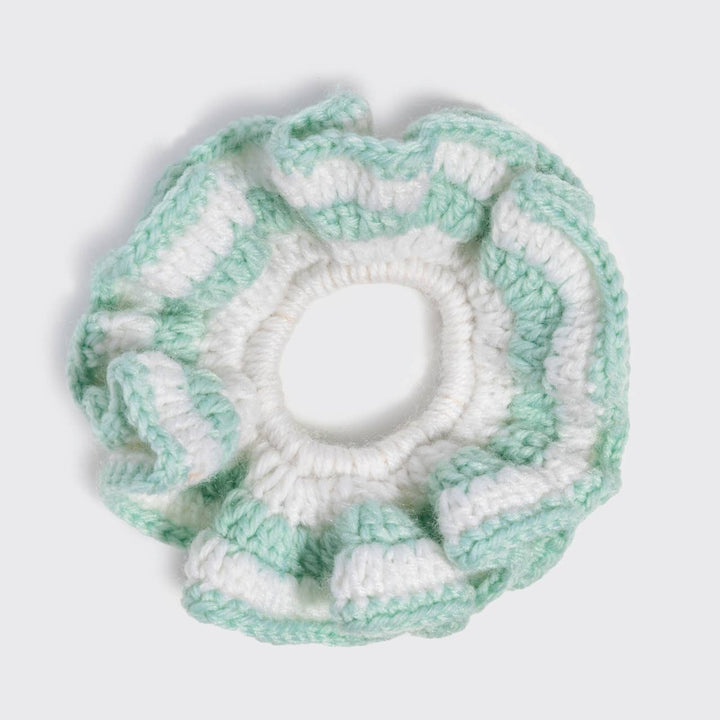 Flat lay top-down view of the Kitsch mint green and white stripe crochet scrunchie with a ruffled, textured edge, on a white background.