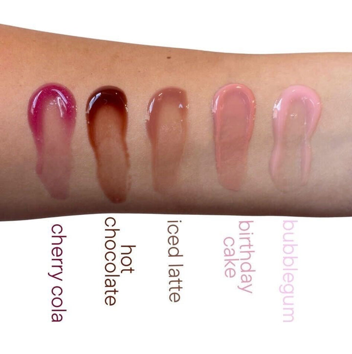 TMLL Beauty Co Pout Plump lip oil swatches in five shades on wrist — cherry cola, hot chocolate, iced latte, birthday cake, and bubblegum