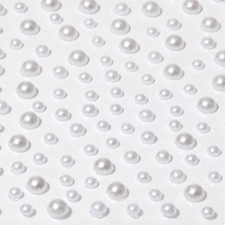 Close-up of Glamnetic white pearl nail decal stickers in assorted sizes on a white background