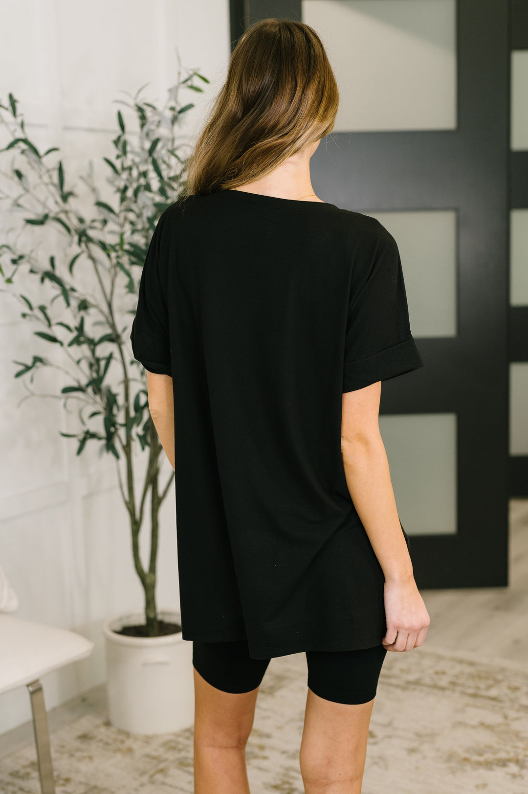 Back view — black oversized V-neck tee and biker shorts