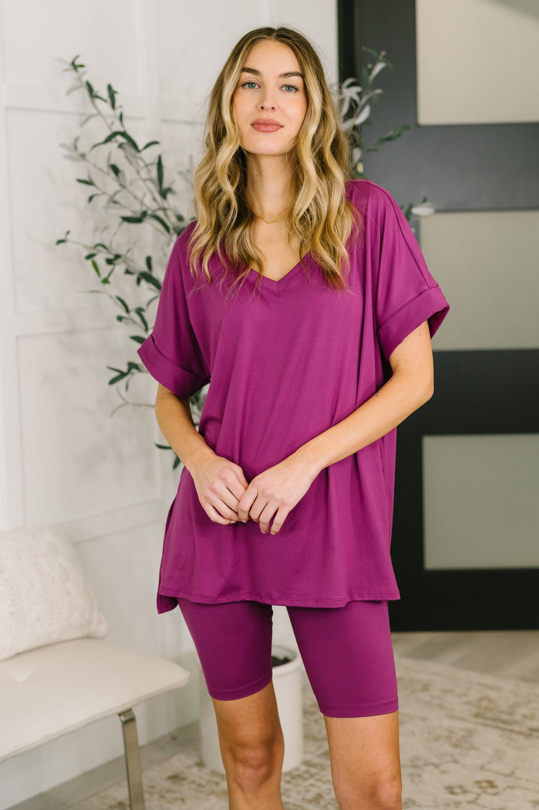 Front view — woman in a light plum oversized V-neck tee and matching biker shorts set