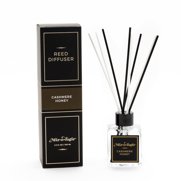 Mixologie Reed Diffuser in Cashmere Honey, 3.3 fl oz, clear square glass bottle with black cap and black label with dark brown accent band, with matching black and brown box