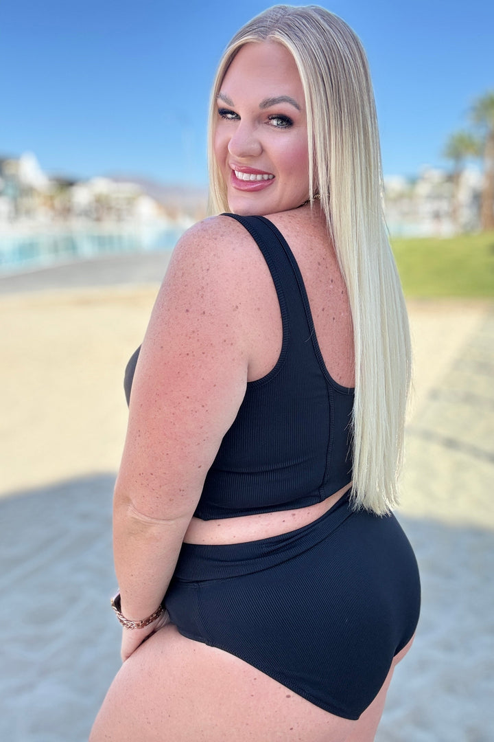 Back view of plus size model wearing a black ribbed textured crop bikini top with square neckline and matching high-waist bikini bottoms 