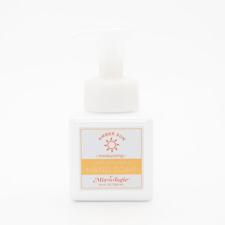 Mixologie Luxe Foaming Hand Soap in Amber Sun, 8.4 fl oz, white square pump bottle with gold-bordered label and orange sun illustration on white background