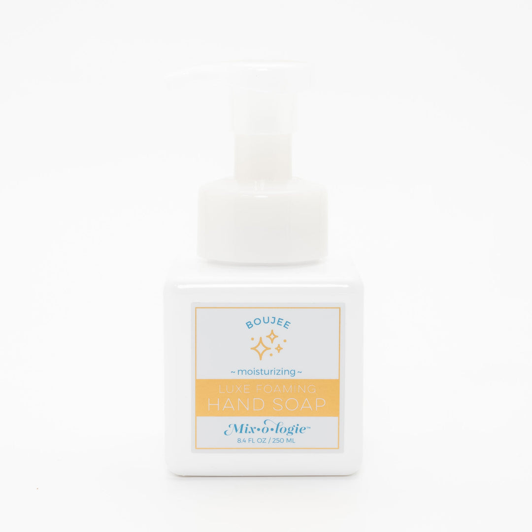 Mixologie Luxe Foaming Hand Soap in Boujee, 8.4 fl oz, white square pump bottle with gold-bordered label and teal and gold sparkle star illustration on white background
