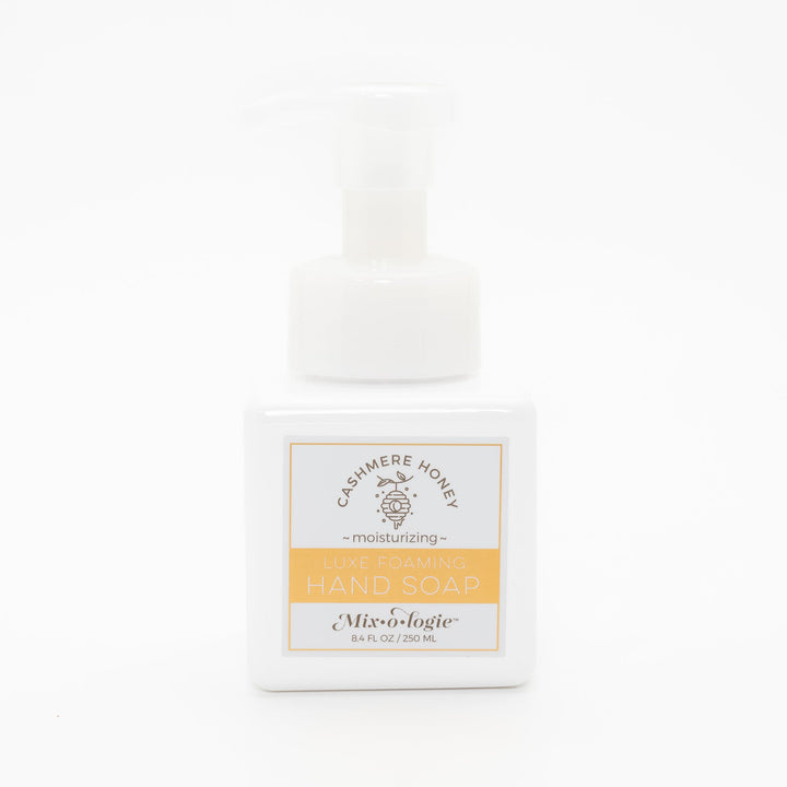 Mixologie Luxe Foaming Hand Soap in Cashmere Honey, 8.4 fl oz, white square pump bottle with gold-bordered label and honeycomb beehive illustration on white background