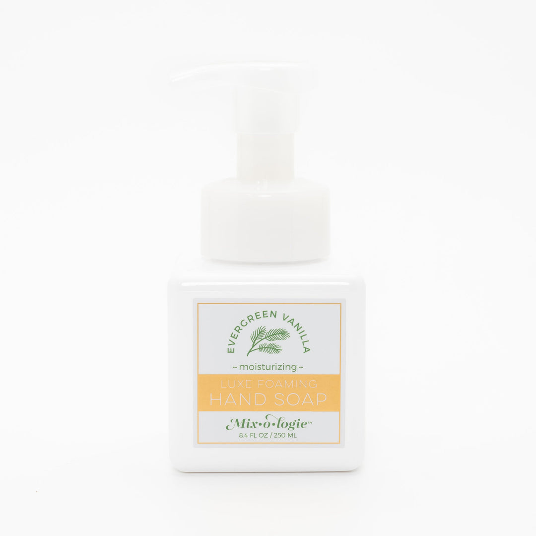 Mixologie Luxe Foaming Hand Soap in Evergreen Vanilla, 8.4 fl oz, white square pump bottle with gold-bordered label and green evergreen branch illustration on white background