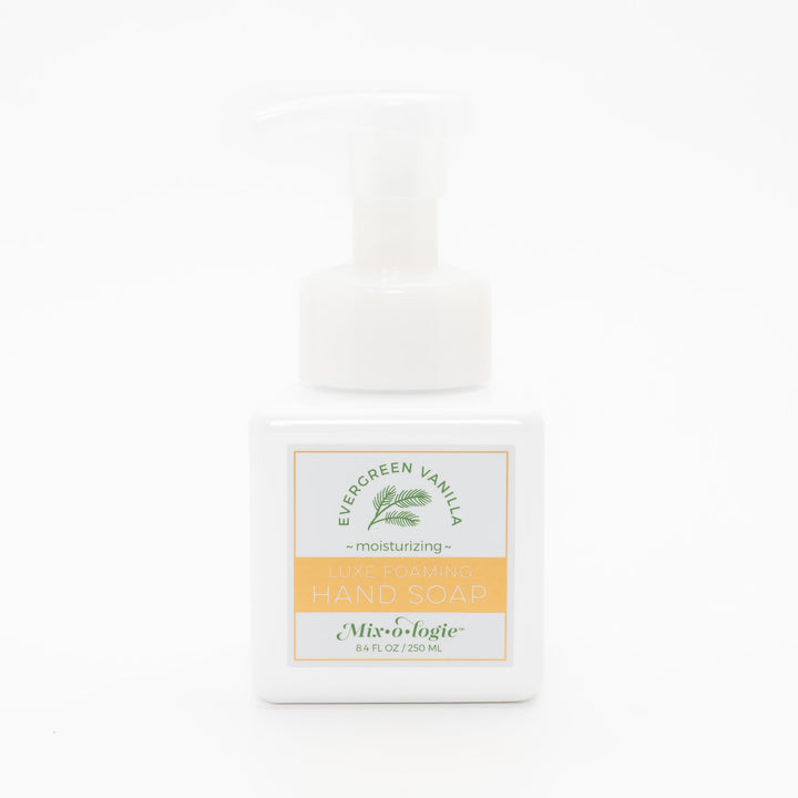 Mixologie Luxe Foaming Hand Soap in Evergreen Vanilla, 8.4 fl oz, white square pump bottle with gold-bordered label and green evergreen branch illustration on white background