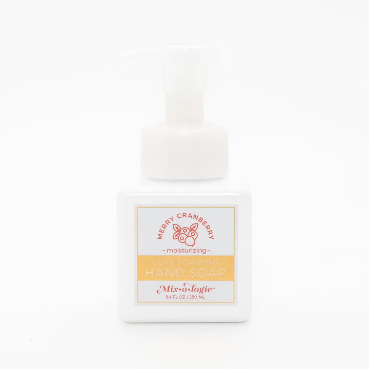 Mixologie Luxe Foaming Hand Soap in Merry Cranberry, 8.4 fl oz, white square pump bottle with gold-bordered label and red cranberry branch illustration on white background