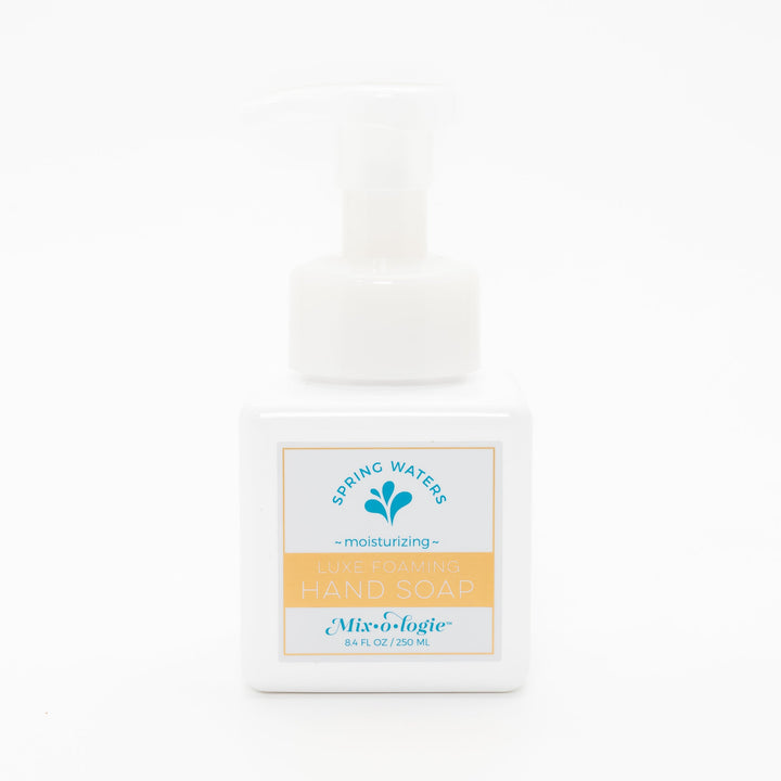 Mixologie Luxe Foaming Hand Soap in Spring Waters, 8.4 fl oz, white square pump bottle with gold-bordered label and teal water droplet splash illustration on white background