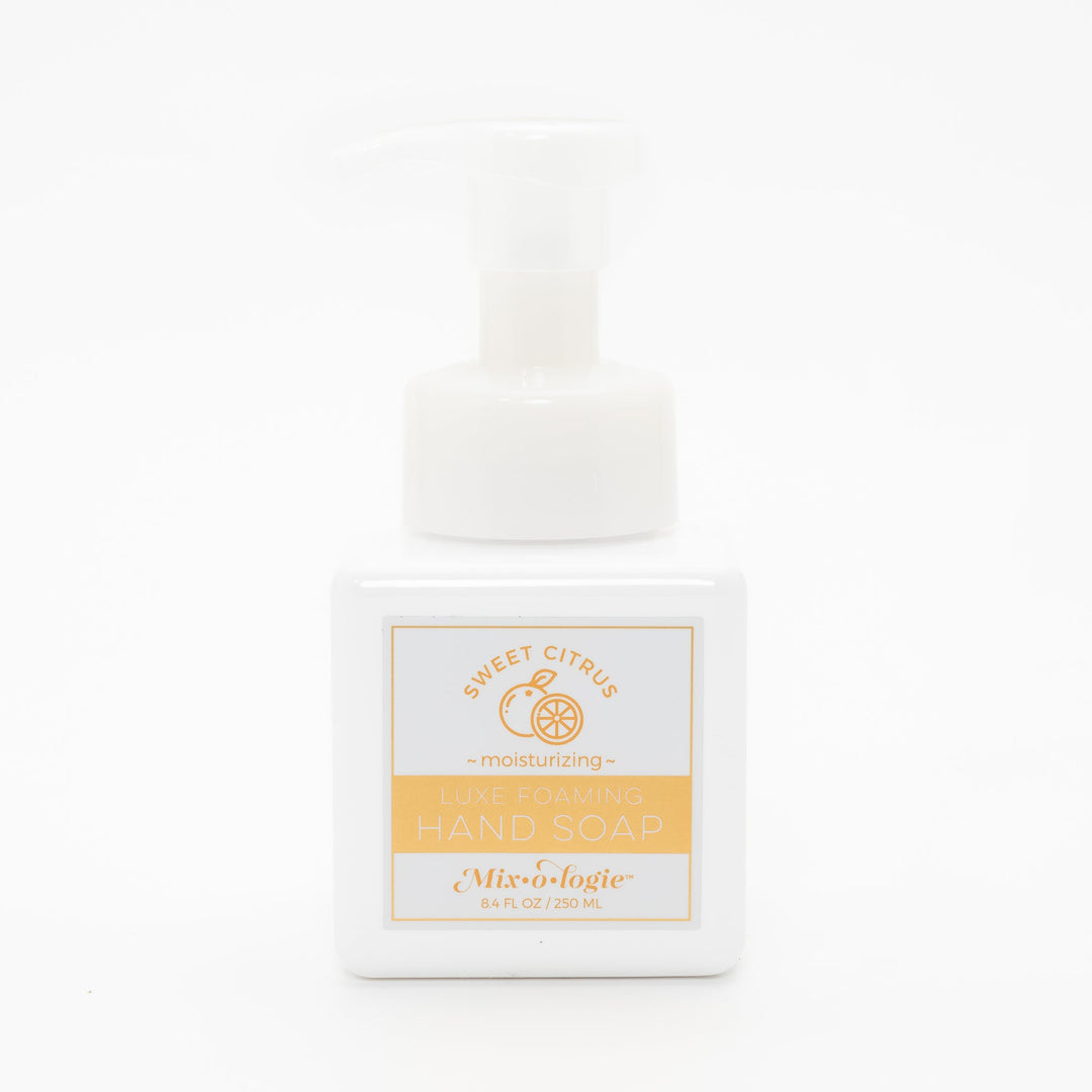 Mixologie Luxe Foaming Hand Soap in Sweet Citrus, 8.4 fl oz, white square pump bottle with gold-bordered label and orange citrus fruit illustration on white background