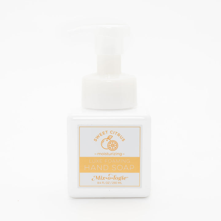 Mixologie Luxe Foaming Hand Soap in Sweet Citrus, 8.4 fl oz, white square pump bottle with gold-bordered label and orange citrus fruit illustration on white background