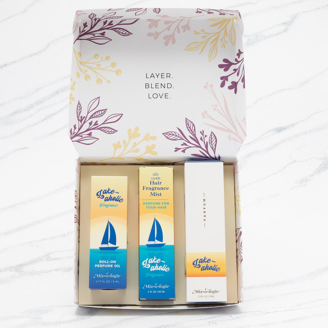 Mixologie Party of Three Gift Set in Lake-aholic open box showing parfum spray, Luxe Hair Fragrance Mist, and roll-on perfume oil in yellow and blue sailboat packaging