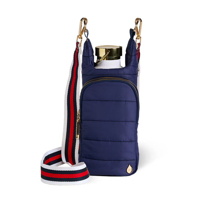 Navy blue insulated bottle bag with red and white strap on a white background