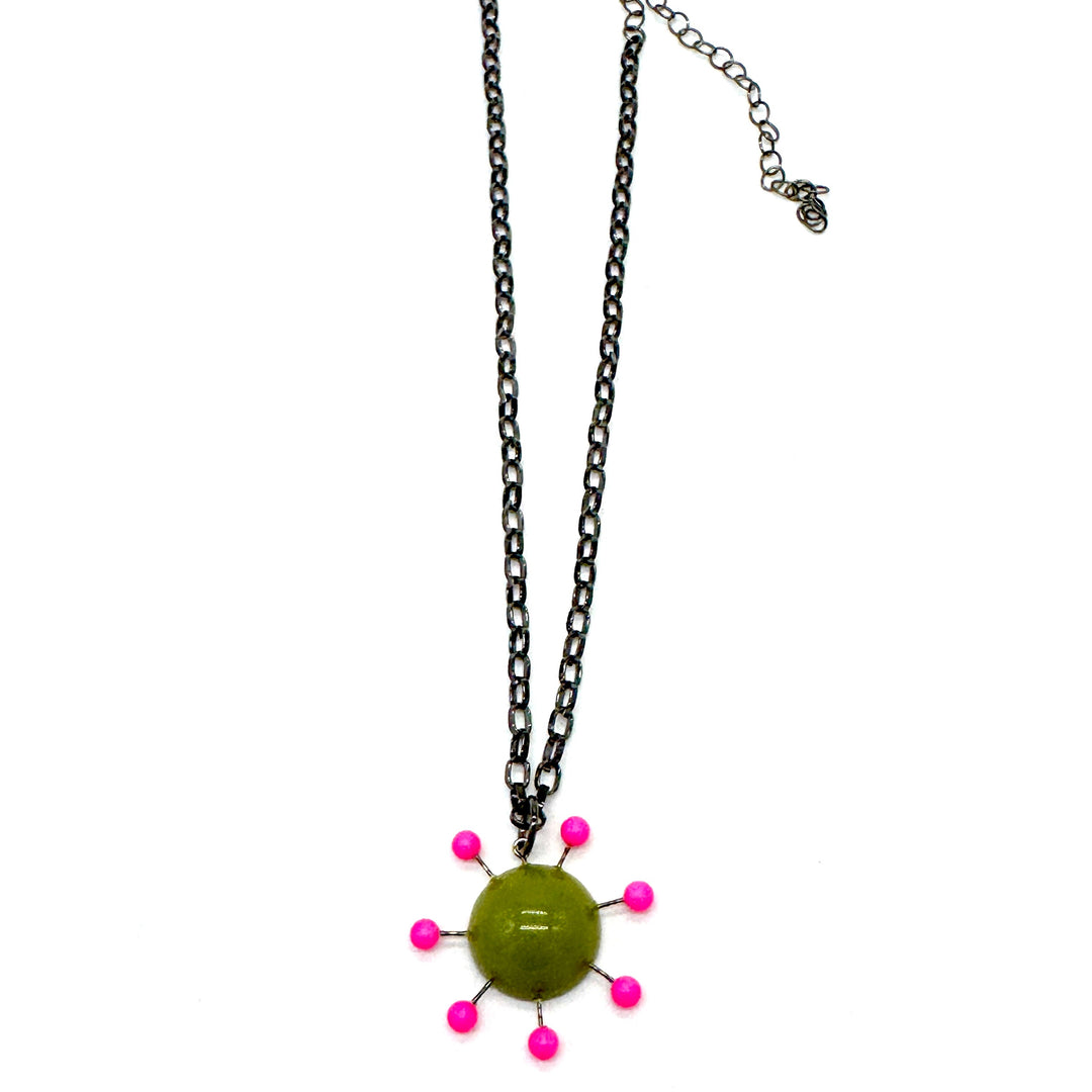 Olive green pendant with hot pink beads radiating around the center, reminiscent of the Sputnik satellite. Pendant hangs on an adjustable chain