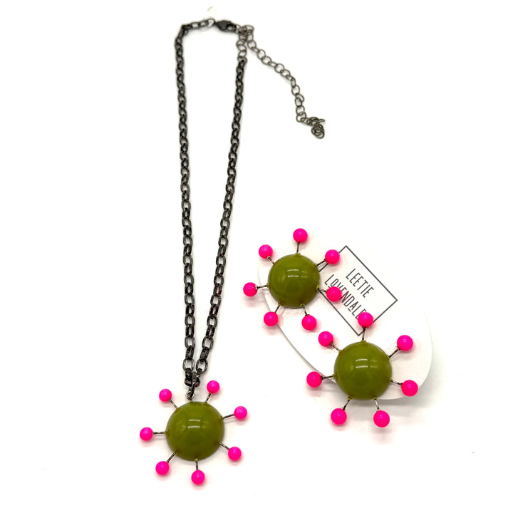 Olive green pendant with hot pink beads radiating around the center, reminiscent of the Sputnik satellite. Pendant hangs on an adjustable chain, matching earrings are shown alongside.