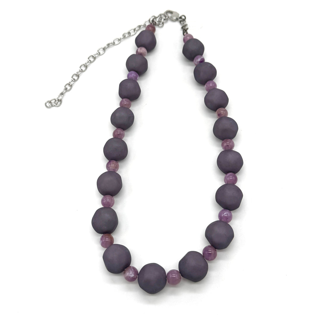 Adjustable necklace featuring dark gray and lilac lucite beads laid on a white background.