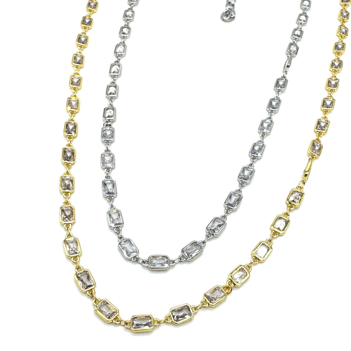 Two gold and silver necklaces with diamond-like stones on a white background