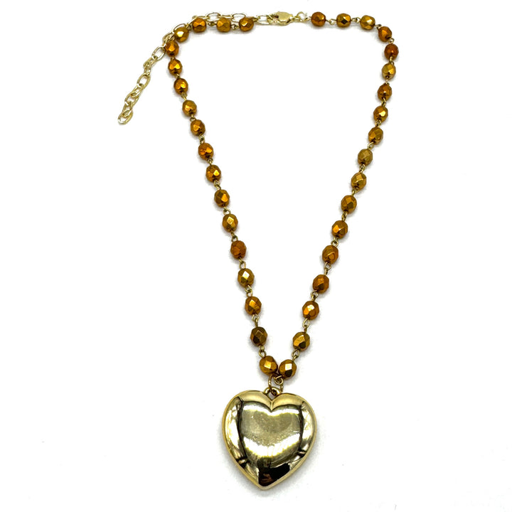 Necklace with heart-shaped pendant and brown beads on a white background
