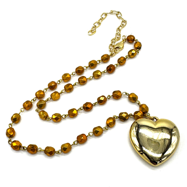 Gold necklace with heart pendant on a white background