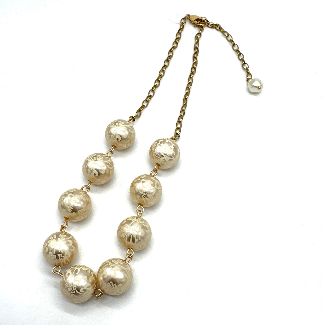 Half chain and half beaded necklace, featuring gold chain and floral etched pearl lucite beads.