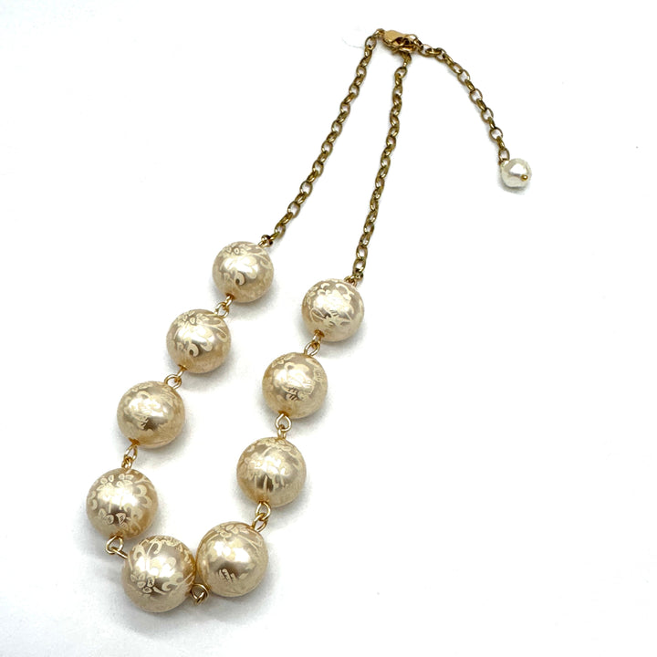 Half chain and half beaded necklace, featuring gold chain and floral etched pearl lucite beads.