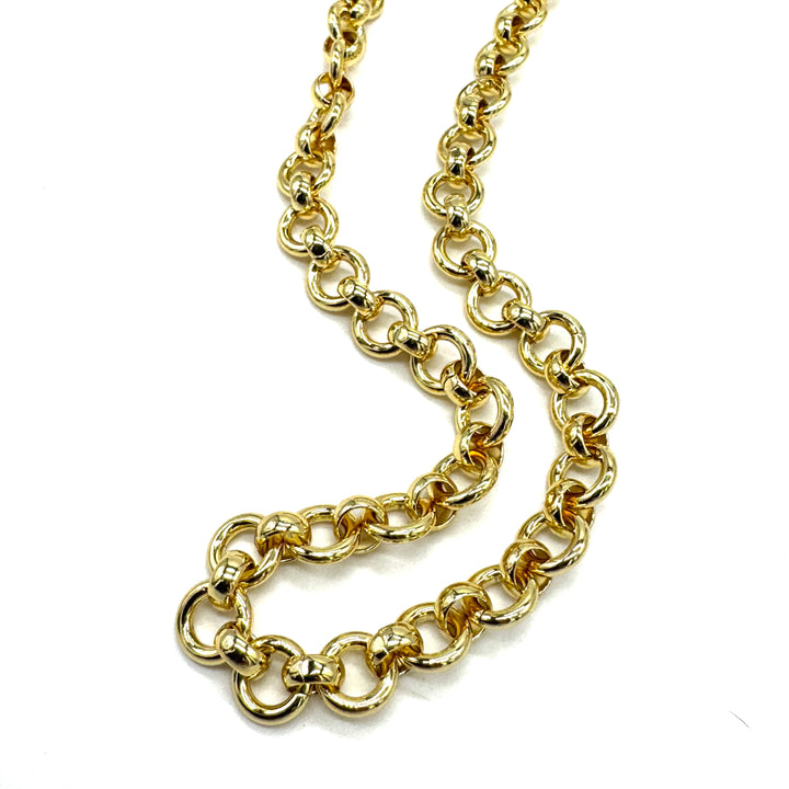 A close-up of a gold chain necklace with large, polished links, arranged in a loose curve on a plain white background.