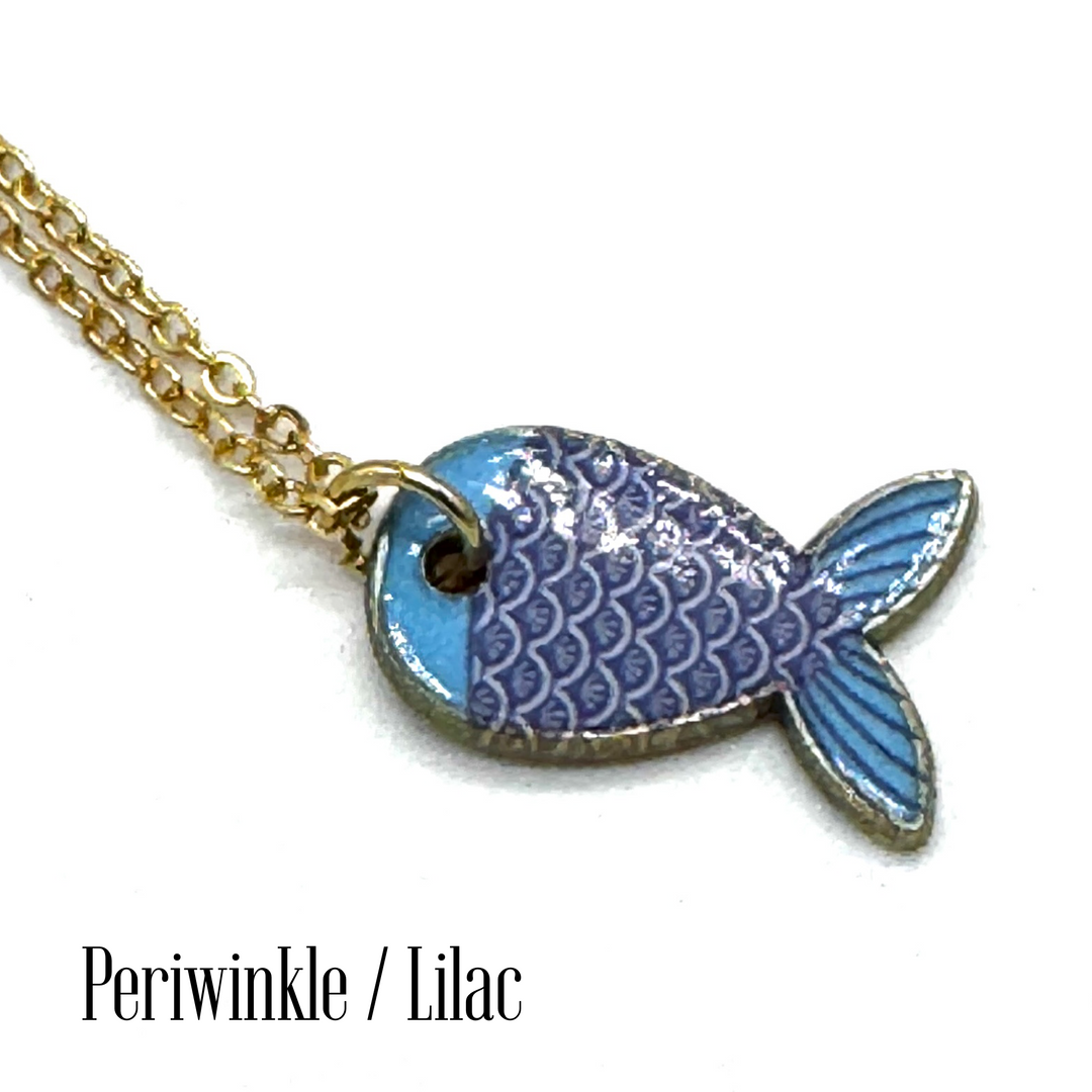A gold chain necklace with a fish-shaped pendant featuring blue and lilac enamel scales, shown on a white background with the text 'Periwinkle / Lilac' at the bottom.