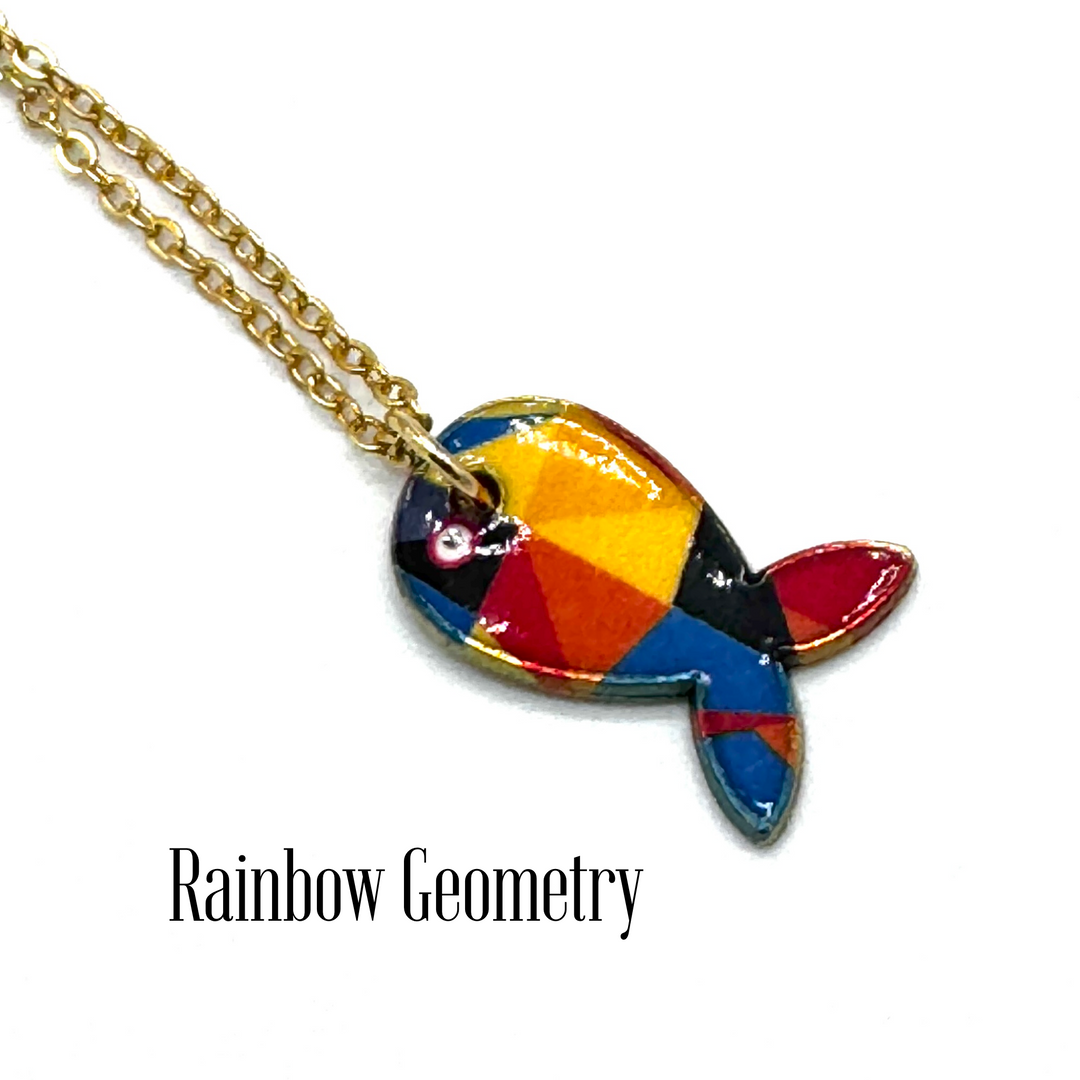 A gold chain necklace with a colorful fish-shaped pendant featuring a geometric rainbow pattern of red, orange, yellow, blue, and black, displayed on a white background with the text 'Rainbow Geometry'.