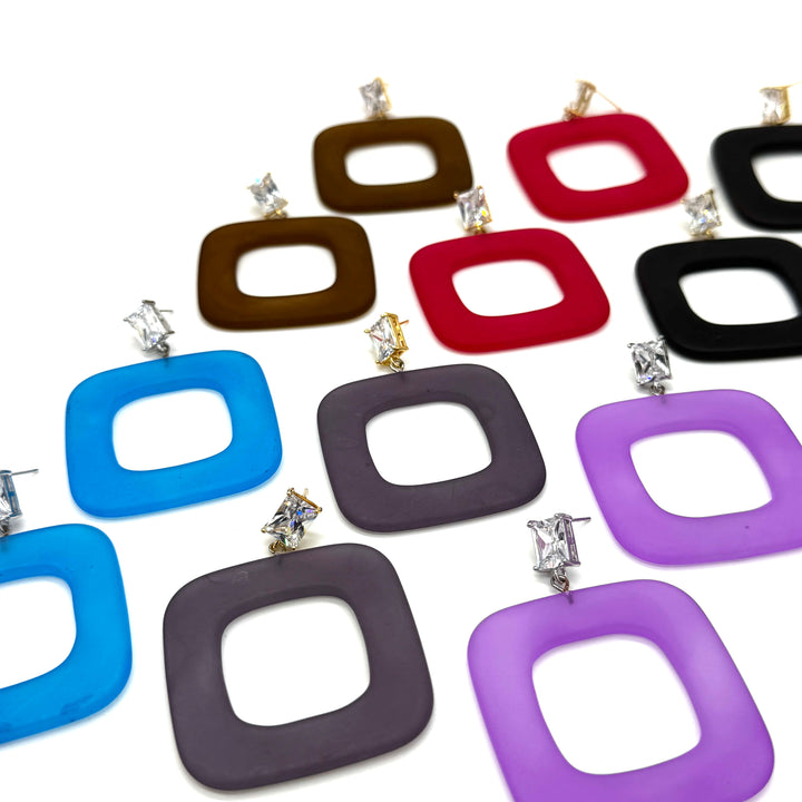 A collection of square-shaped drop earrings with rounded corners, featuring a hollow center and a small clear rhinestone stud at the top. The earrings are shown in multiple colors, including blue, dark gray, purple, red, brown, black, and purple, arranged on a plain white background.
