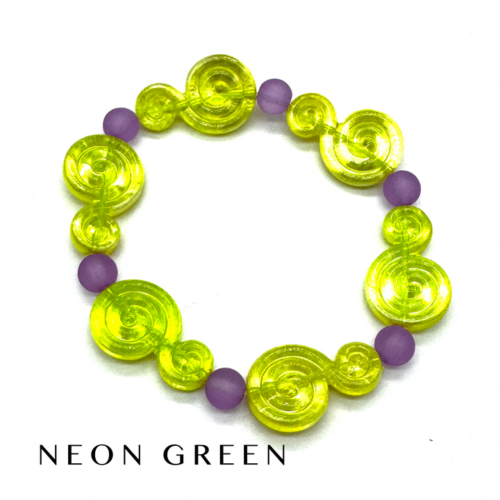 A beaded stretch bracelet featuring translucent neon green spiral-shaped beads and matte purple round beads, displayed on a white background with the text 'NEON GREEN' underneath.