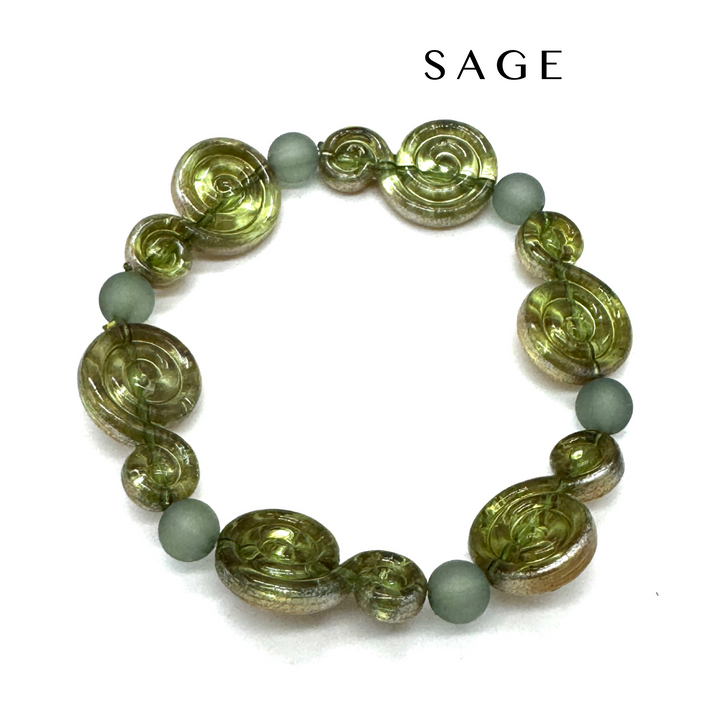 A beaded stretch bracelet featuring textured olive green spiral beads and matte sage green round beads, displayed on a clean white background with the brand name 'SAGE' printed above.