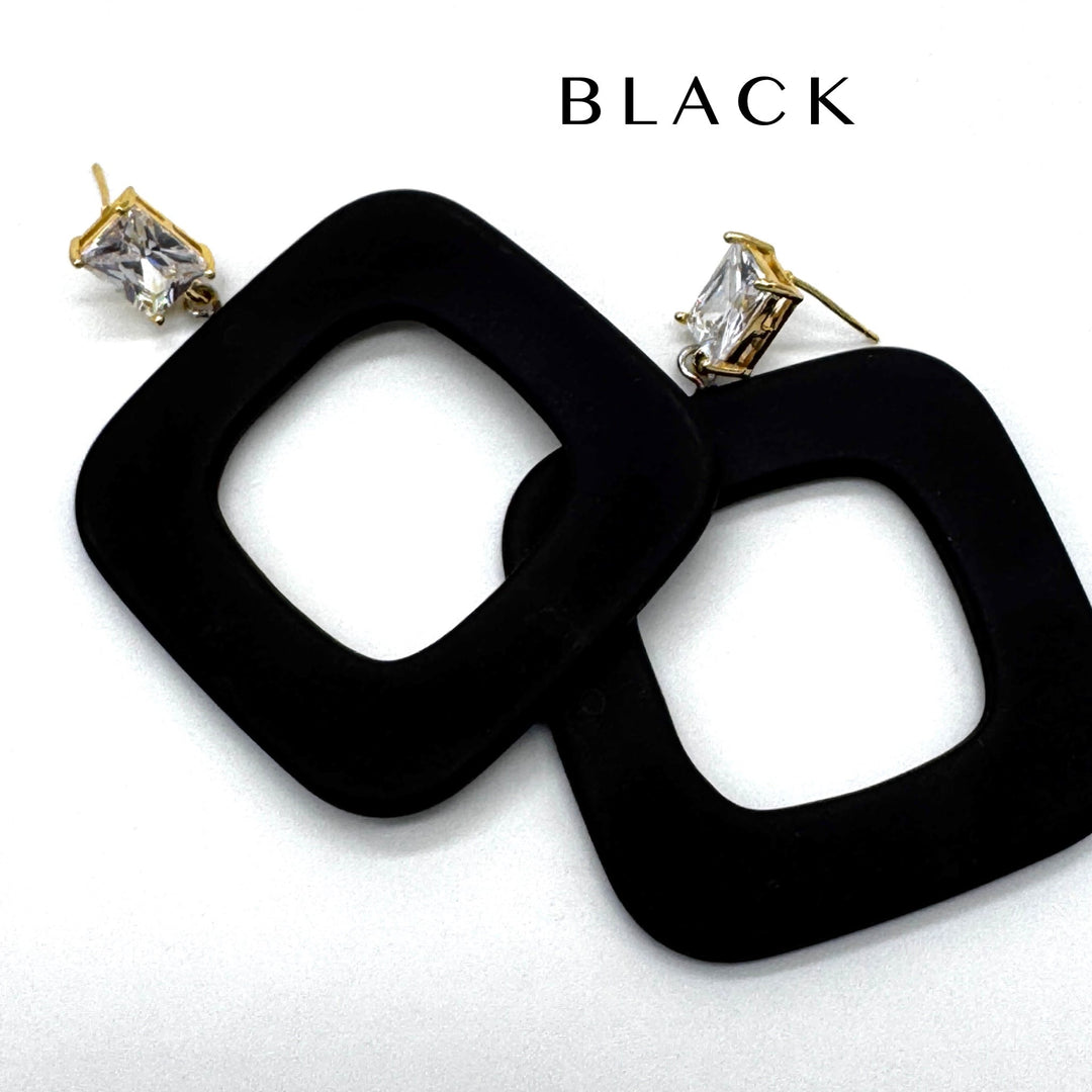 Black square drop earrings with gold-tone posts and clear rectangular crystals, shown on a white background with the word 'BLACK' printed above.