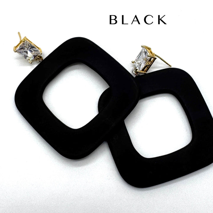 Black square drop earrings with gold-tone posts and clear rectangular crystals, shown on a white background with the word 'BLACK' printed above.