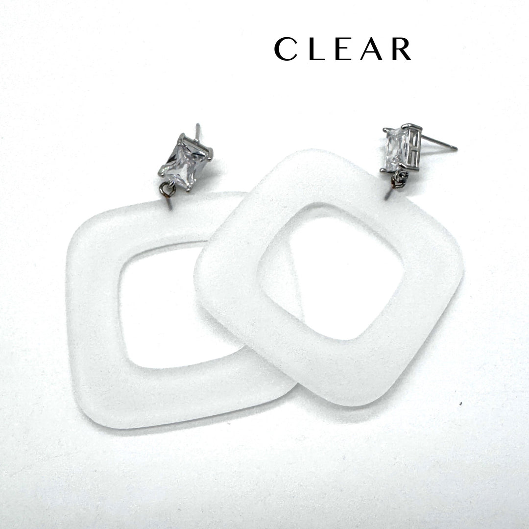 Two chunky square drop earrings made of clear frosted lucite, shown on a plain white background with the word 'CLEAR' printed above.