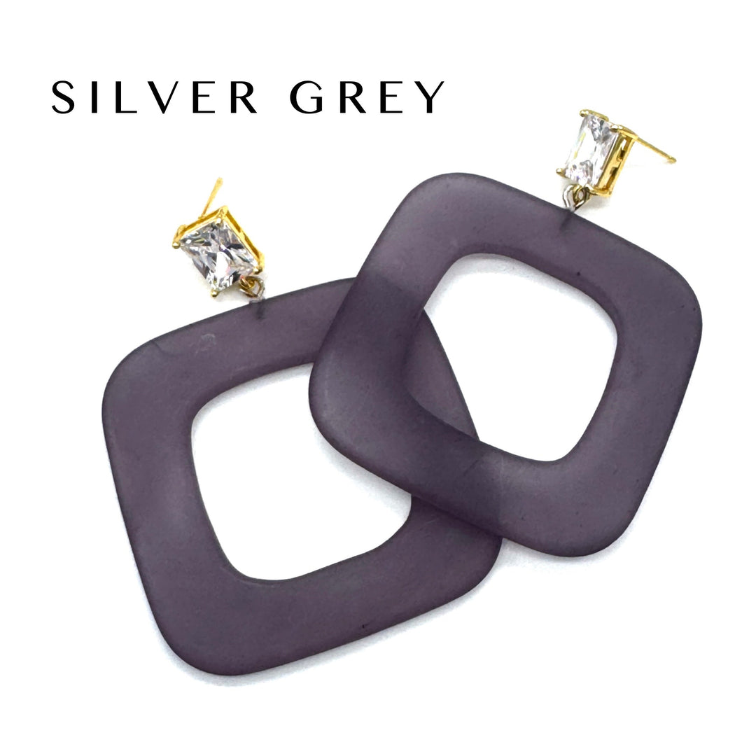 Square open-frame dangle earrings in a dark greyish-purple color with gold-tone posts and clear rhinestones, shown on a white background with the text 'SILVER GREY' at the top.