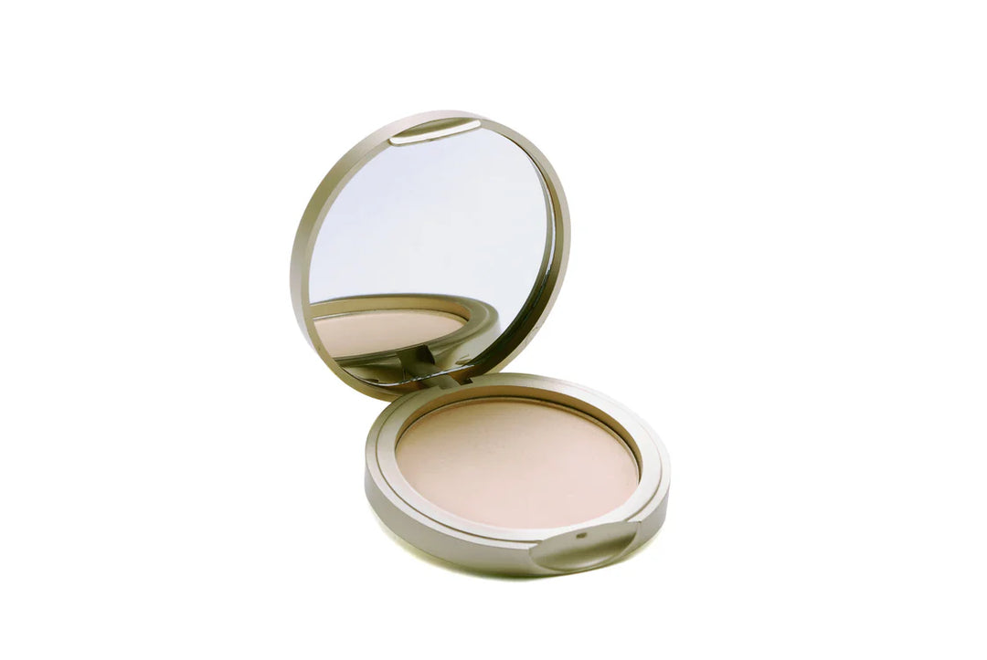 Open round compact powder with mirror lid in champagne gold case showing light beige pressed powder on white background