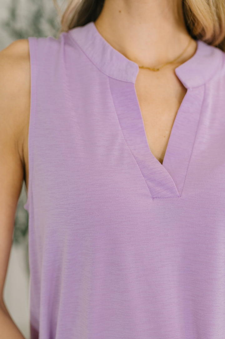 Close-up of the lavender split-neck neckline with subtle notch detail and a delicate gold necklace.