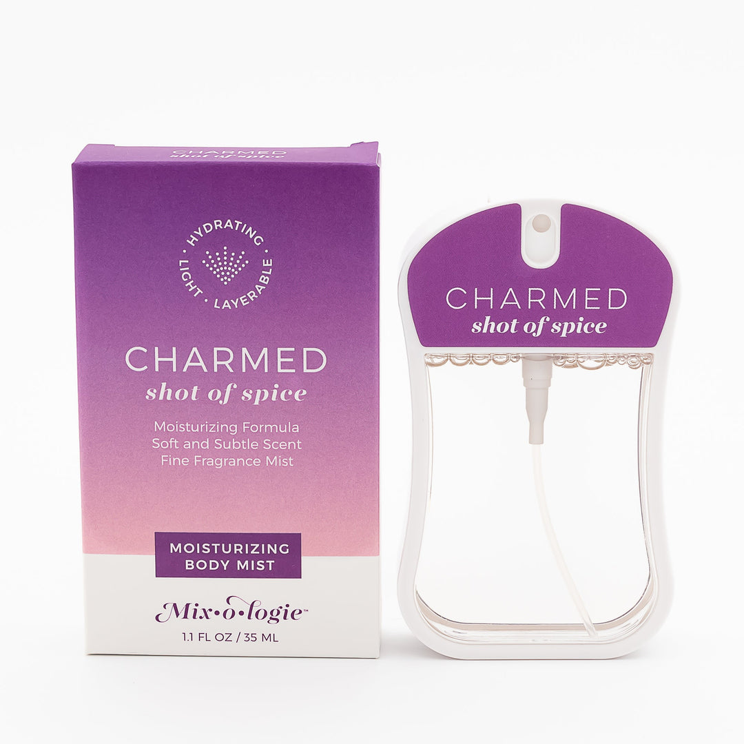Mixologie Moisturizing Body Mist in Charmed Shot of Spice, 1.1 fl oz, clear card-shaped spray bottle with purple cap next to purple to pink gradient box on white background