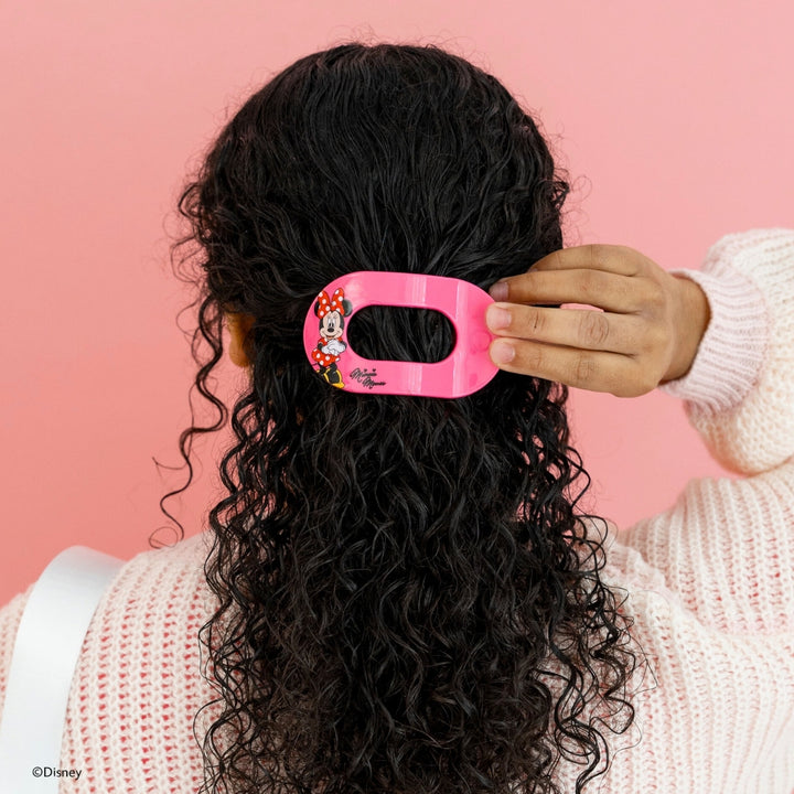 Disney x Teleties Minnie Mouse medium flat round hair clip in hot pink with Minnie Mouse character graphic being placed in half-down style on curly dark hair against pink background