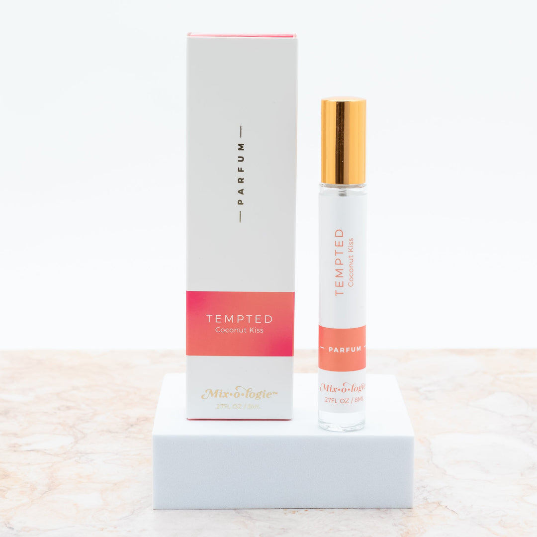 Mixologie Parfum in Tempted Coconut Kiss, 0.27 fl oz, clear glass roller bottle with gold cap and coral pink box
