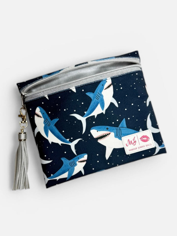 Makeup Junkie Bags large fabric zip clutch in navy shark print with silver glitter zipper and silver tassel on light gray background