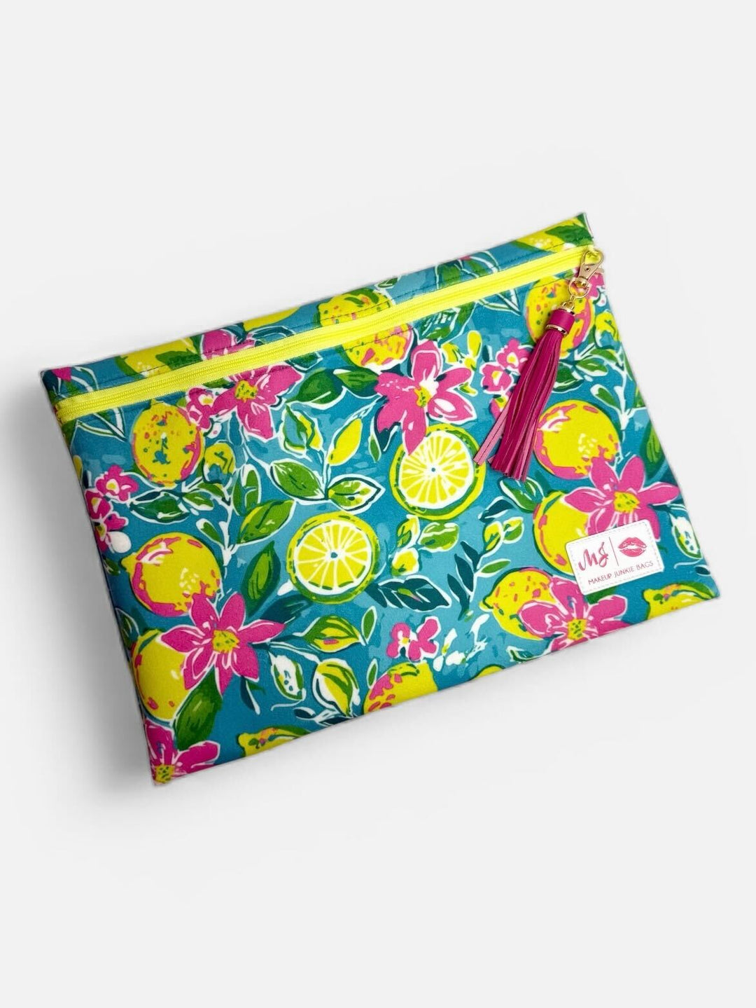 Makeup Junkie Bags large flat zip clutch in teal lemon and floral print with yellow zipper and pink tassel on light gray background
